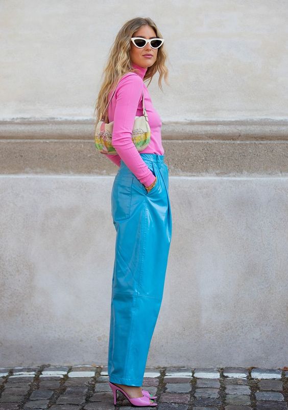 clashing color outfits by pairing a pink turtleneck sweater and heels with blue latex straight pants