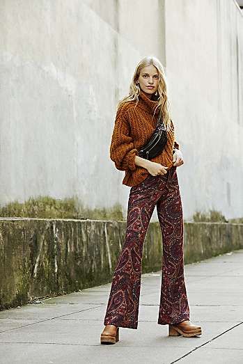 printed bootcut pants and brown turtle neck sweaters
