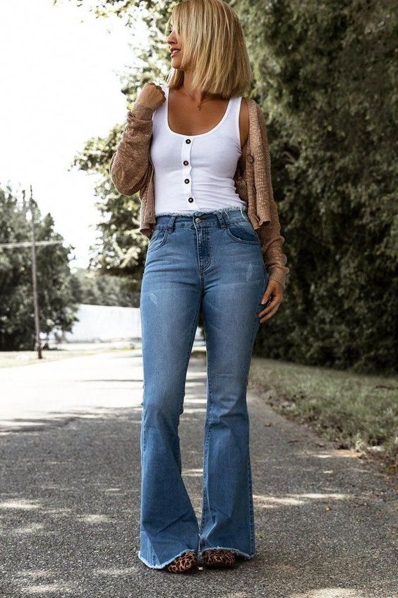 button-down sleeveless tops, a knitted cardigan, and boot-cut jeans for vintage style