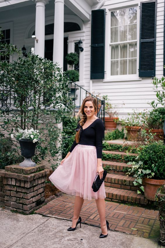 valentine's day outfit idea in a long sleeve v neck black tee and a pink chiffon skirt