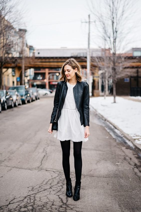 mini dress style in winter in a white dress, black legging, and leather jackets